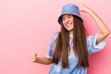 Pembe arka planda izole edilmiş beyaz bir kadın zaferden sonra yumruğunu kaldırıyor, kazanan konsept.