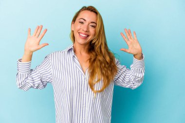 Mavi arka planda izole edilmiş beyaz kadın on numarayı elleriyle gösteriyor..