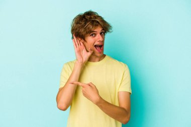 Mavi arka planda soyutlanmış beyaz bir adam bir dedikoduyu dinlemeye çalışıyor..