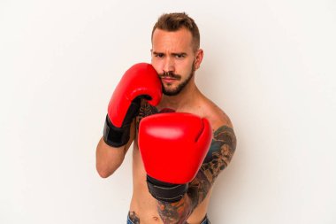 Beyaz arka planda dövmeleri olan beyaz tenli genç boksör.