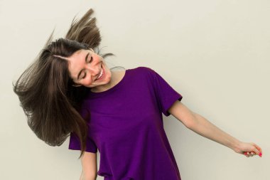 Sarı arka planda izole edilmiş genç beyaz kadın dans ediyor ve eğleniyor..