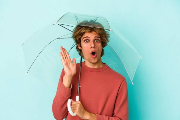Elinde Makyaj Şemsiyesi Olan Beyaz Bir Adam Mavi Arka Planda — Stok fotoğraf