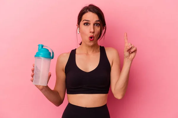 ピンクの背景に単離されたタンパク質を飲む若い白人女性は いくつかの素晴らしいアイデア 創造性の概念を持っている — ストック写真