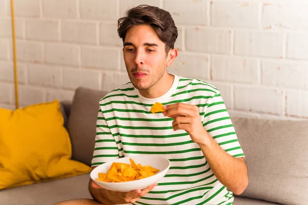 Joven Mestizo Comiendo Patatas Fritas Sentado Sofá — Foto de Stock