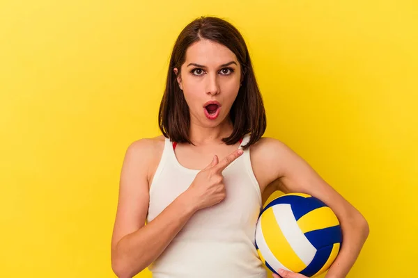 Молода Біла Жінка Грає Волейбол Ізольовано Жовтому Тлі Вказуючи Бік — стокове фото