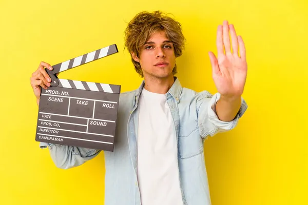 Young Caucasian Man Makeup Holding Clapperboard Isolated Yellow Background Standing — Stock Photo, Image