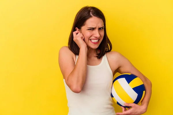 Молода Біла Жінка Грає Волейбол Ізольовано Жовтому Фоні Покриваючи Вуха — стокове фото