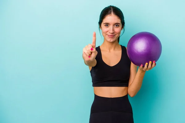 Young Caucasian Fitness Woman Holding Ball Isolated Blue Background Showing — Stock Photo, Image