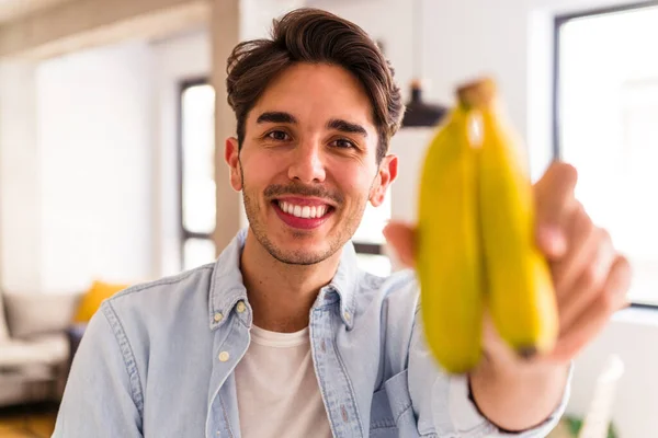 Młody Mieszane Rasy Człowiek Jedzenie Banan Kuchni Jego Domu — Zdjęcie stockowe