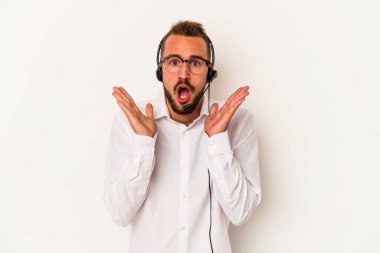 Beyaz arka planda izole edilmiş dövmeleri olan beyaz pazarlamacı genç adam şaşırdı ve şok oldu..