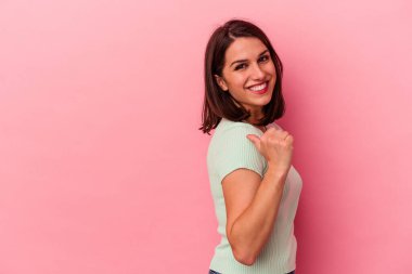 Pembe arka plan noktalarında izole edilmiş genç beyaz kadın başparmak uzakta, gülüyor ve kaygısız..