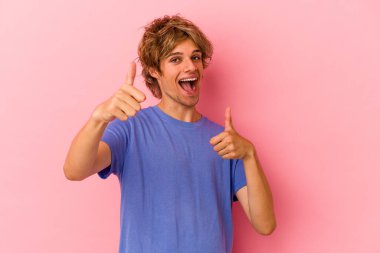 Pembe arka planda soyutlanmış, gülümseyen ve kendine güveni tam beyaz bir genç..