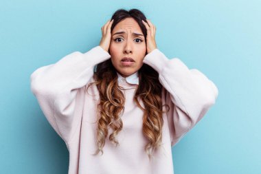 Mavi arka planda izole edilmiş genç Meksikalı kadın şok geçiriyordu. Önemli bir buluşmayı hatırladı..