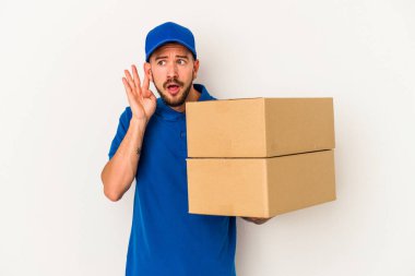 Beyaz arka planda izole edilmiş dövmeleri olan beyaz bir teslimatçı bir dedikoduyu dinlemeye çalışıyor..