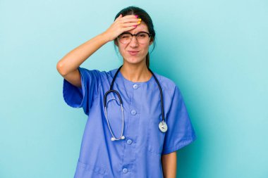 Mavi arka planda izole genç beyaz hemşire şok oldu, o önemli bir toplantı hatırladı.