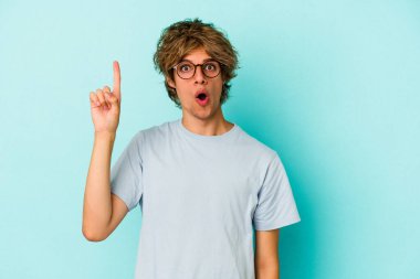 Mavi arka planda soyutlanmış beyaz makyajlı genç bir adamın harika bir fikri var, yaratıcılık kavramı..