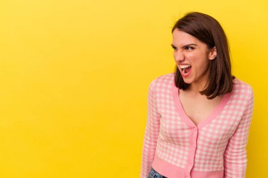 Sarı arka planda izole edilmiş genç beyaz kadın çok kızgın, öfkeli, hayal kırıklığına uğramış.