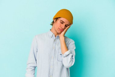 Mavi arka planda soyutlanmış, sıkılmış, yorgun ve dinlenmeye ihtiyacı olan beyaz, genç bir adam..