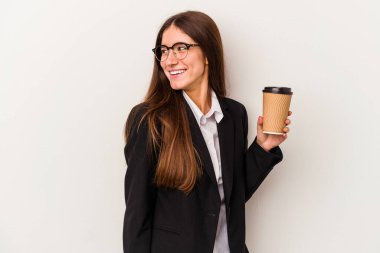 Beyaz arka planda izole edilmiş kahve içen beyaz iş kadını gülümsüyor, neşeli ve keyifli görünüyor..