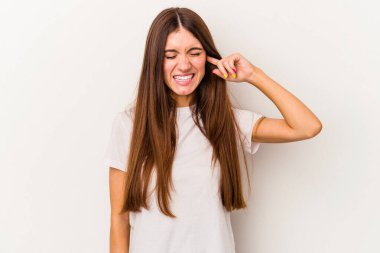 Beyaz arka planda izole edilmiş genç beyaz kadın kulaklarını elleriyle kapatıyor..