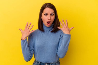 Sarı arka planda izole edilmiş genç beyaz kadın on numarayı elleriyle gösteriyor..