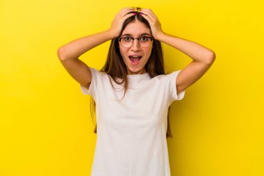 Sarı arka planda izole edilmiş genç beyaz kadın çığlık atıyor, çok heyecanlı, tutkulu, bir şeyden memnun..