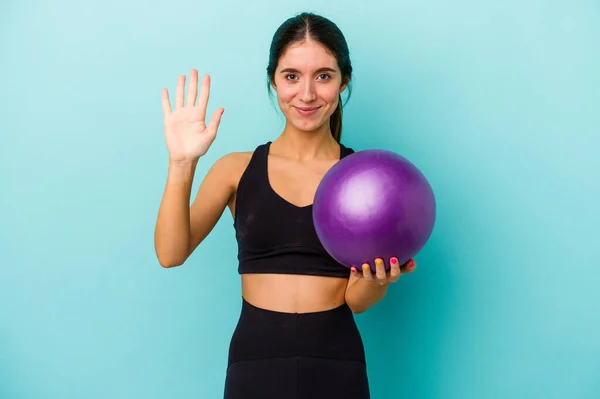 Jonge Kaukasische Fitness Vrouw Met Een Bal Geïsoleerd Blauwe Achtergrond — Stockfoto