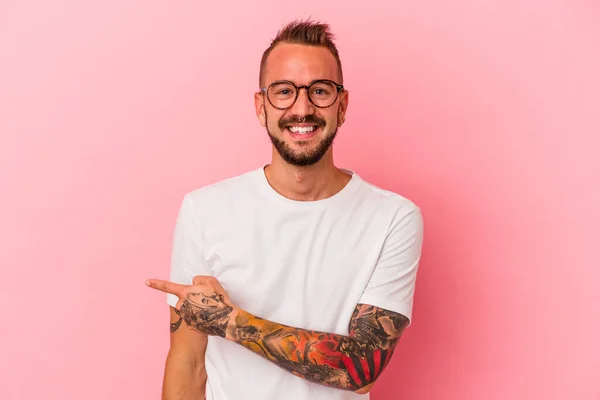 Mladý Běloch Tetováním Izolovaným Růžovém Pozadí Usmívající Ukazující Stranou Ukazující — Stock fotografie