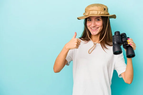 Junge Kaukasische Forscherin Hält Ferngläser Isoliert Auf Blauem Hintergrund Lächelt — Stockfoto