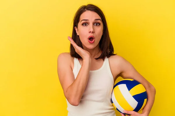 Joven Mujer Caucásica Jugando Voleibol Aislado Sobre Fondo Amarillo Sorprendido —  Fotos de Stock