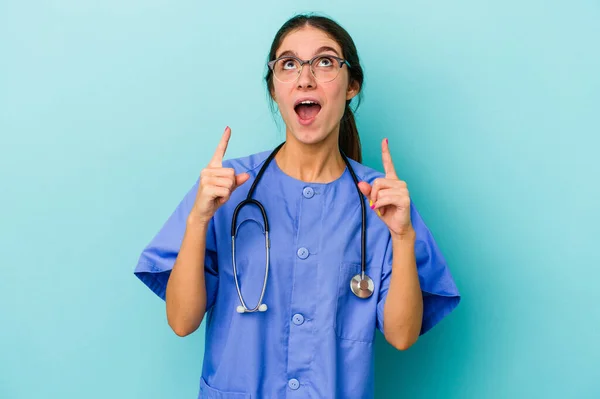 Jovem Enfermeira Caucasiana Isolada Fundo Azul Apontando Cabeça Com Boca — Fotografia de Stock