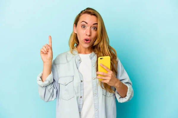 Kaukasiska Kvinna Som Håller Mobiltelefon Isolerad Blå Bakgrund Har Någon — Stockfoto