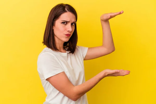 Mujer Joven Caucásica Aislada Sobre Fondo Amarillo Sosteniendo Algo Con —  Fotos de Stock