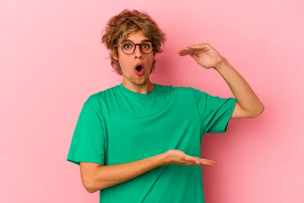 Homem Caucasiano Jovem Com Maquiagem Isolada Fundo Rosa Segurando Algo — Fotografia de Stock