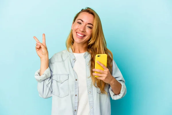 Vit Kvinna Som Håller Mobiltelefon Isolerad Blå Bakgrund Glad Och — Stockfoto