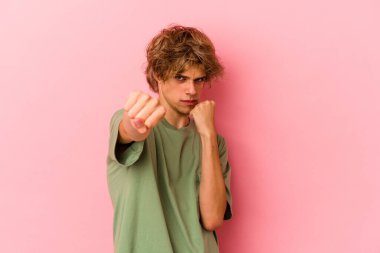 Pembe arka planda soyutlanmış beyaz tenli genç bir adam bir tartışma yüzünden yumruk, öfke, kavga atıyor, boks yapıyor..