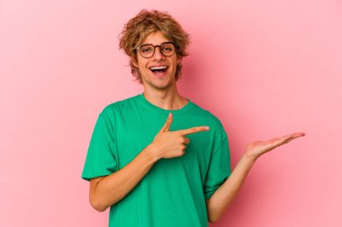 Pembe arka planda soyutlanmış beyaz makyajlı genç bir adam Palm 'da bir fotokopi alanı tuttuğu için heyecanlı..