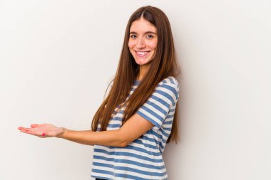 Beyaz arka planda izole edilmiş beyaz tenli genç bir kadın palmiyesinde bir kopya alanı tutuyor..