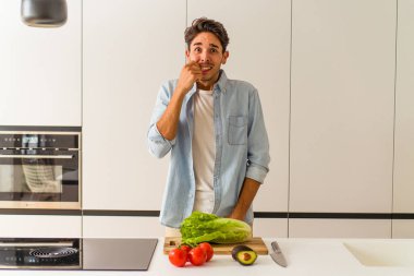 Genç melez adam öğle yemeği için salata hazırlıyor tırnaklarını yiyor, gergin ve çok endişeli..