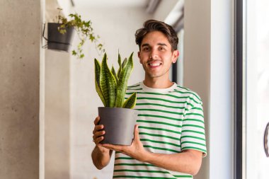 Evinde bitki yetiştiren melez bir adam.