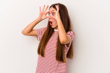 Beyaz arka planda izole genç beyaz kadın bir başarı fırsatı bulmak için gözlerini açık tutuyor..