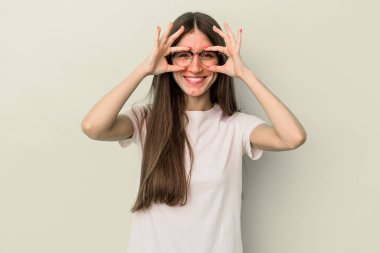 Sarı arka planda izole edilmiş genç beyaz kadın gözlerinde sorun olmadığını gösteriyor.