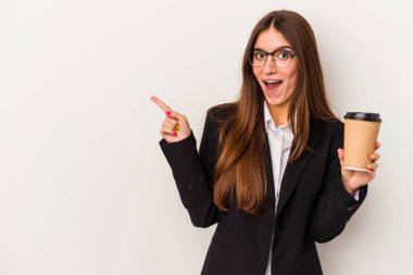 Beyaz arka planda izole edilmiş kahve tutan beyaz iş kadını gülümsüyor ve boş alanda bir şey gösteriyor..