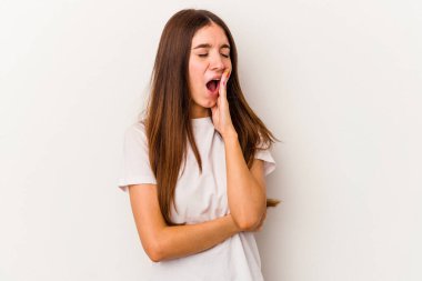 Beyaz arka planda izole edilmiş genç beyaz kadın esniyor. Ağzı eliyle kapatan yorgun bir hareket sergiliyor..