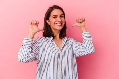 Pembe arka planda izole genç beyaz kadın gururlu ve kendinden emin hissediyor, örnek olarak..