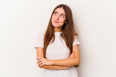 Beyaz arka planda izole edilmiş genç beyaz kadın hedeflere ve amaçlara ulaşmayı hayal ediyor.