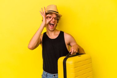 Makyajlı genç beyaz adam sarı arka planda izole bir şekilde seyahat edecek..