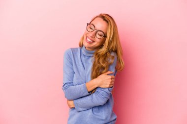 Kafkasyalı sarışın kadın pembe arka planda izole edilmiş gülüyor ve eğleniyor..