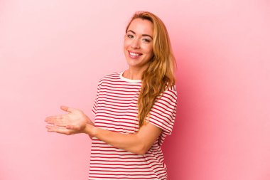 Kafkasyalı sarışın kadın pembe arka planda izole edilmiş. Elinde bir fotokopi odası var..