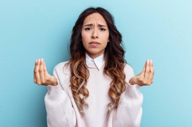 Mavi arka planda izole edilmiş genç Meksikalı kadın hiç parası olmadığını gösteriyor..